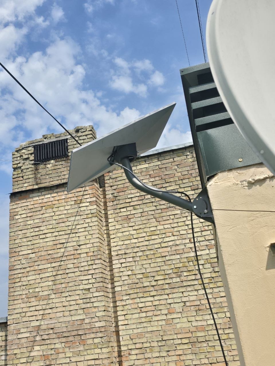 Starlink terminal wall-mounted on brick rooftop structure in Kyiv, Ukraine